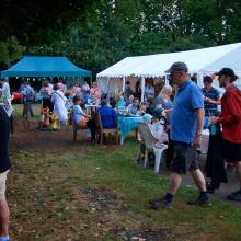 a communal space on the allotment with a marquee and gazebo and people around